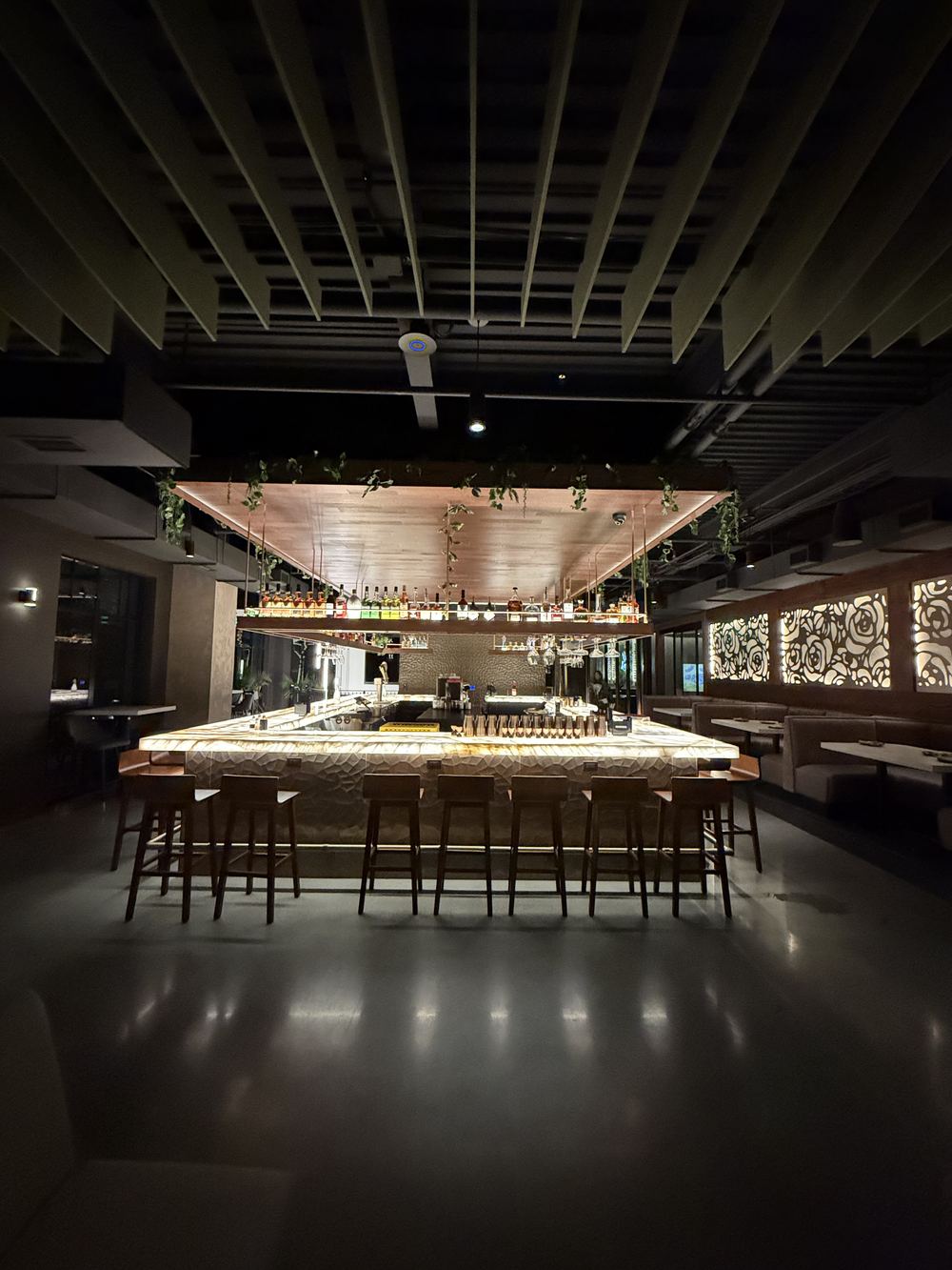 The empty Kasi bar after close, lit from within and reset for the next service