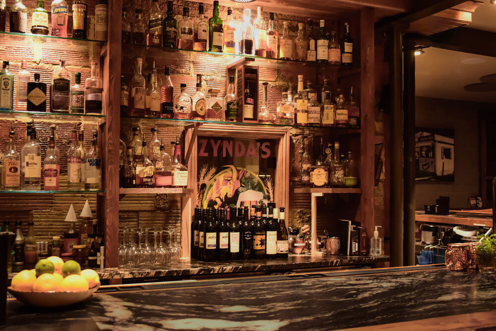 The back bar at Zynda's, lit shelves of whiskey and gin against exposed brick