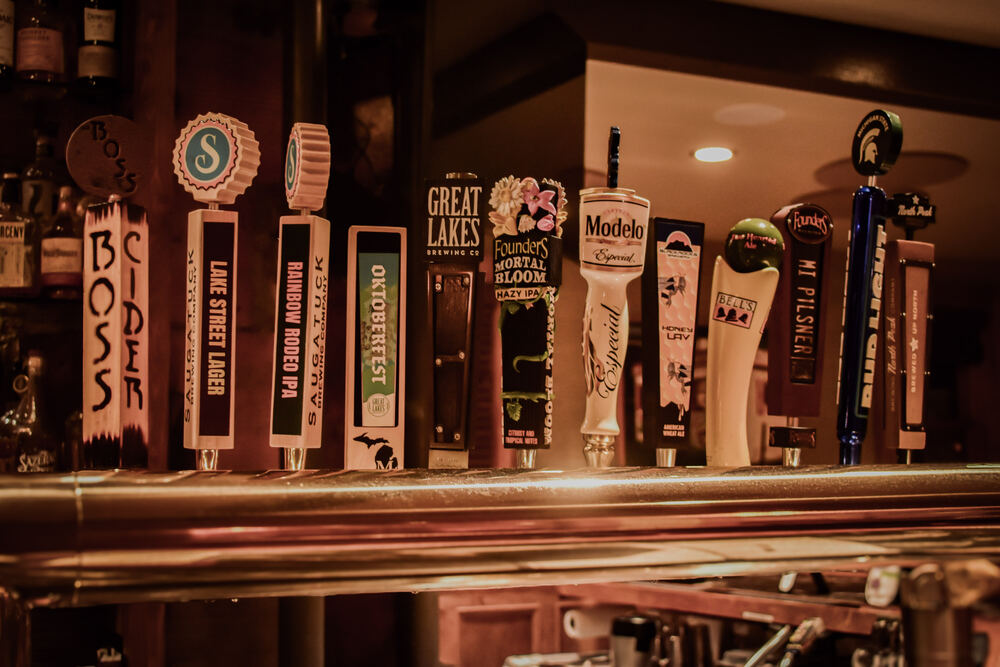 A row of twelve tap handles at Zynda's, mostly Michigan breweries including Saugatuck, Founders and Bell's